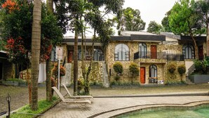 A stone building with a pool, a lounge chair, and a staircase leading to the entrance. - Nimo Resort Ciater (Ciater)