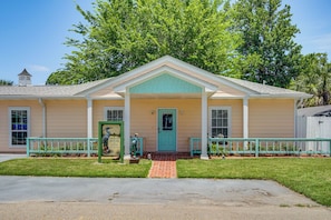 A two-story building with a front porch, a small tower, and a signboard.