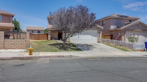 A residential street with houses, a tree, a fire hydrant, and a garage. - Convenient High Desert Stay Near Route 66 (Victorville)