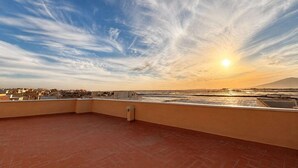 Eine Dachterrasse mit freiem Blick auf die Stadtlandschaft und ein entferntes Gebirge.