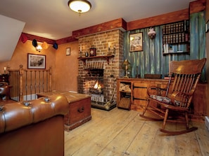 Ein gemütliches Zimmer mit Kamin, Holzmöbeln und einer Bücherwand.