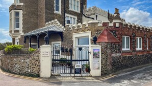 A castle-like building with a stone facade, a gated entrance, and a sign for 'BLEAK HOUSE.' - 2 bedroom accommodation in Broadstairs (Broadstairs)