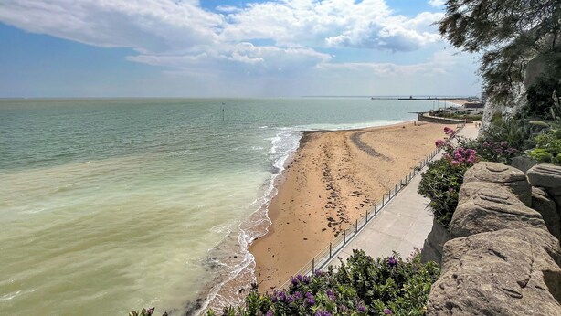 A beach with clear water, a sandy shore, and a rocky cliff with vegetation. - 2 bedroom accommodation in Broadstairs (Broadstairs)