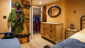 A bedroom with a wooden wardrobe, a dresser, a mirror, and a bed. - 2 bedroom accommodation in Broadstairs (Broadstairs)