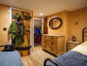 Ein Schlafzimmer mit einem Holfischschrank, einem Schminktisch, einem Spiegel und einem Bett.