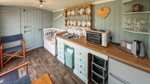 A compact kitchen with a wooden countertop, a built-in oven, and a small refrigerator. - Ewe - Nice - UK51949 (Sutton on Sea, near Mablethorpe)