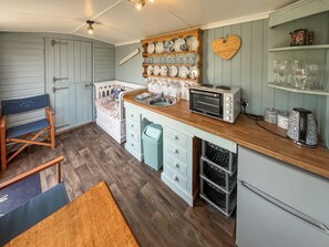 A compact kitchen with a wooden countertop, a built-in oven, and a small refrigerator. - Ewe - Nice - UK51949 (Sutton on Sea, near Mablethorpe)