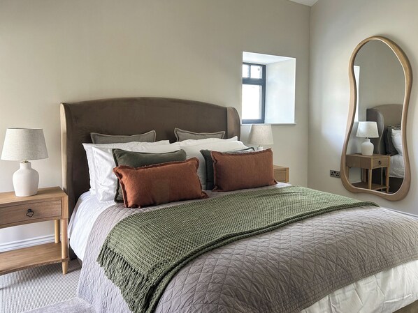 A neatly made bed with a quilted cover, a bedside lamp, and a nightstand with a drawer. - 1 bedroom accommodation in Consett (Consett)