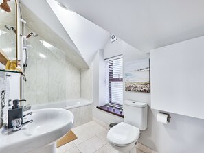 A modern bathroom with a bathtub, toilet, and sink. - No.6 Golf Terrace Apartments - UK52021 (Portrush)