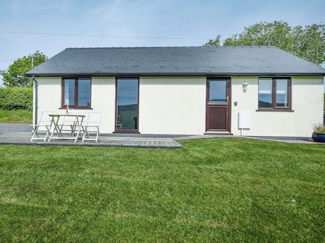 A small, single-story building with a flat roof, large windows, and a door.. 2 bedroom accommodation in Brecon, Near Hay-on Wye