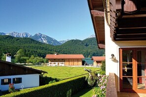 Bergblick mit einem Holzhaus, einem weißen Haus und blauem Himmel.