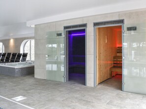 A modern indoor pool area with a glass-enclosed hot tub, a wooden sauna, and a tiled floor. - Pabi - Poppy - UKC7077 (Nansidyll)