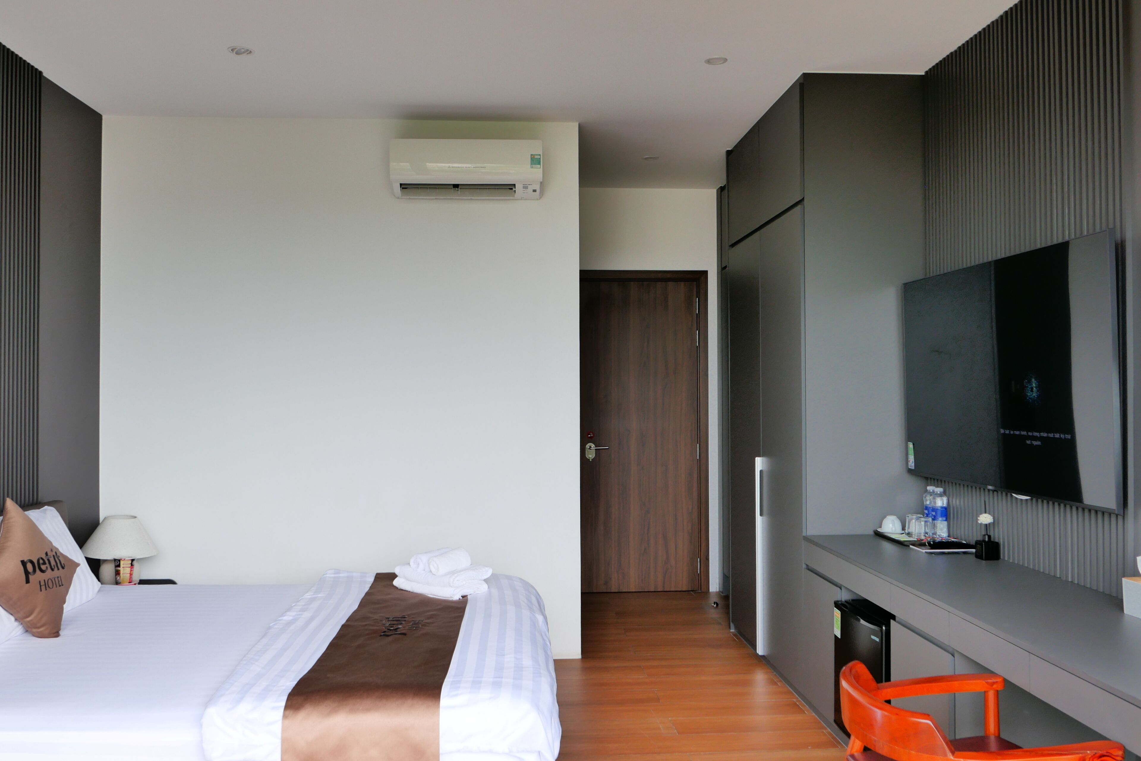 Une chambre d’hôtel avec un lit, une télévision, un bureau et une chaise.
