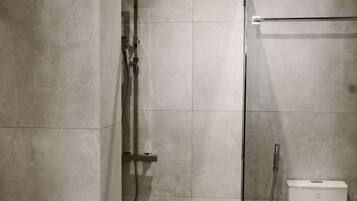 Un baño moderno con ducha, inodoro y lavamanos.