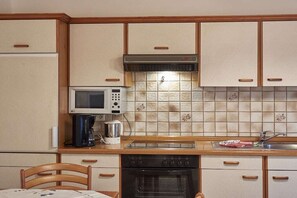 A compact kitchen with a microwave, coffee maker, and oven. - Amselhof am Kurpark 2 (Bodenmais)