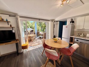 Eine moderne Küche mit Essbereich, Fernseher und Ausblick.