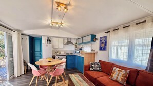 Een compacte leefruimte met een eethoek, een bank en een kitchenette.