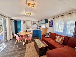 Ein kompakter Wohnbereich mit Essplatz, einer Couch und einer Küchenzeile.