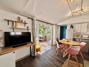 Eine moderne Küche mit Essbereich, Fernseher und Bücherregal.