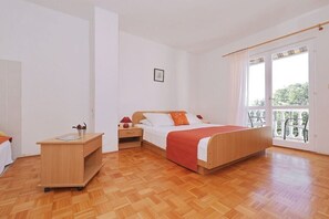 Ein Schlafzimmer mit Bett, Nachttischen, einem Schreibtisch und einem Fenster mit Blick.