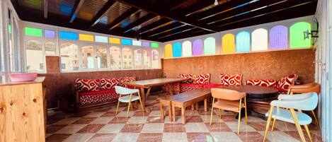A restaurant with checkered flooring, wooden tables, and benches.