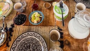 Mesa posta com diversos pratos, talheres e um bule.