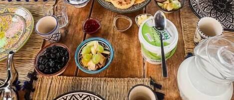 A dining table set with various dishes, utensils, and a teapot.