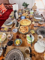 A dining table set with various dishes, utensils, and a teapot.