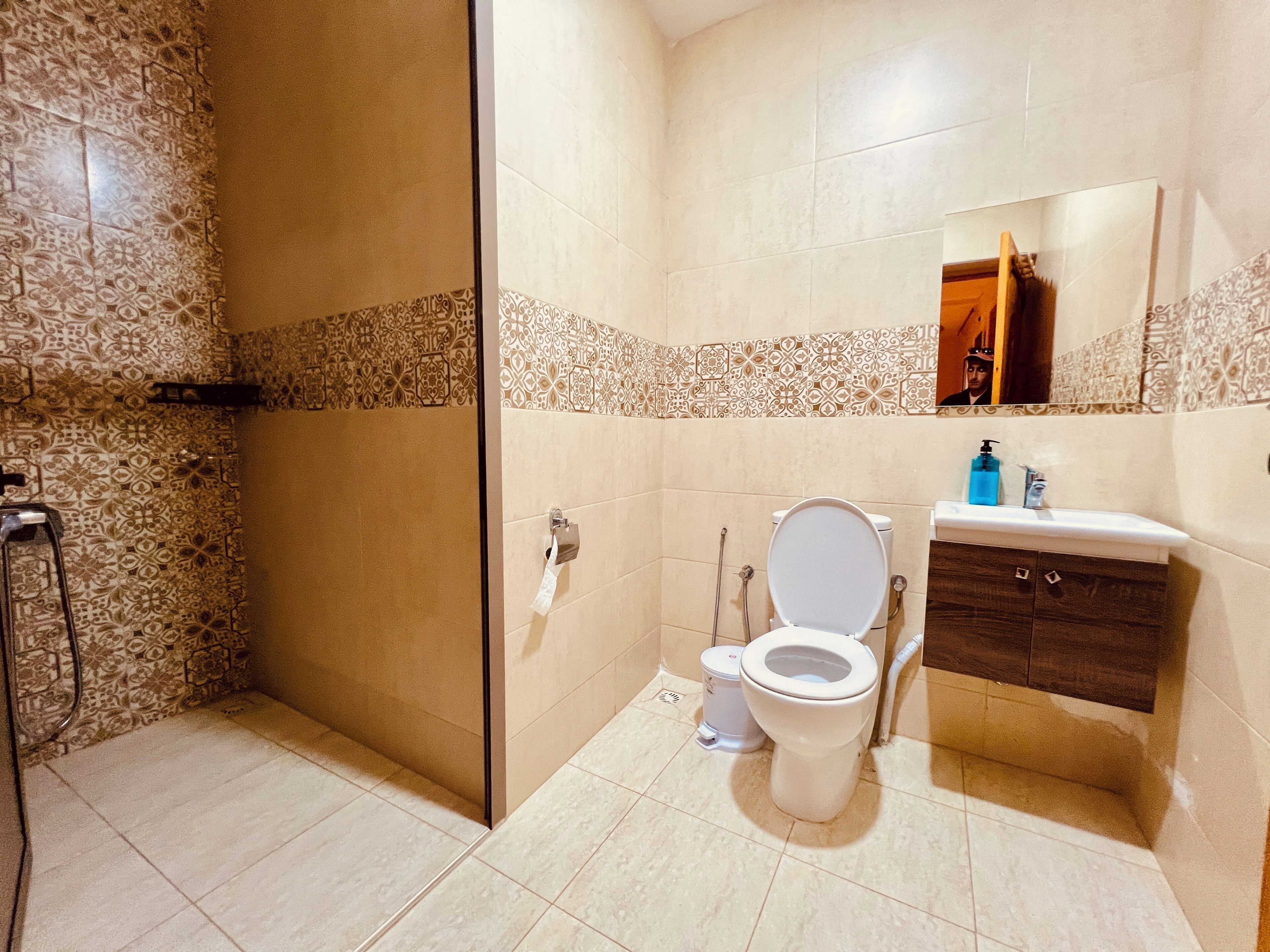 Un baño con inodoro, lavabo y zona de ducha.