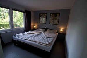 Ein Schlafzimmer mit einem Bett, zwei Wandlampen und zwei gerahmten Bildern.