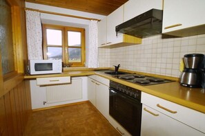 Eine kleine Küche mit Mikrowelle, Herd und Kaffeemaschine.