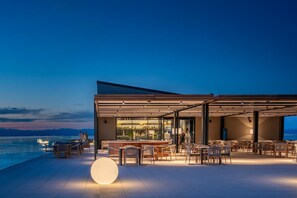 Terraza en la azotea con mobiliario, zona de bar y vistas al horizonte de la ciudad.