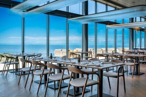 A restaurant with tables and chairs arranged indoors, overlooking a scenic view. - Deluxe Studio in Crveni Vrh (Crveni Vrh)