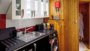 Uma cozinha compacta com máquina de lavar, pia e manta anti-incêndio.