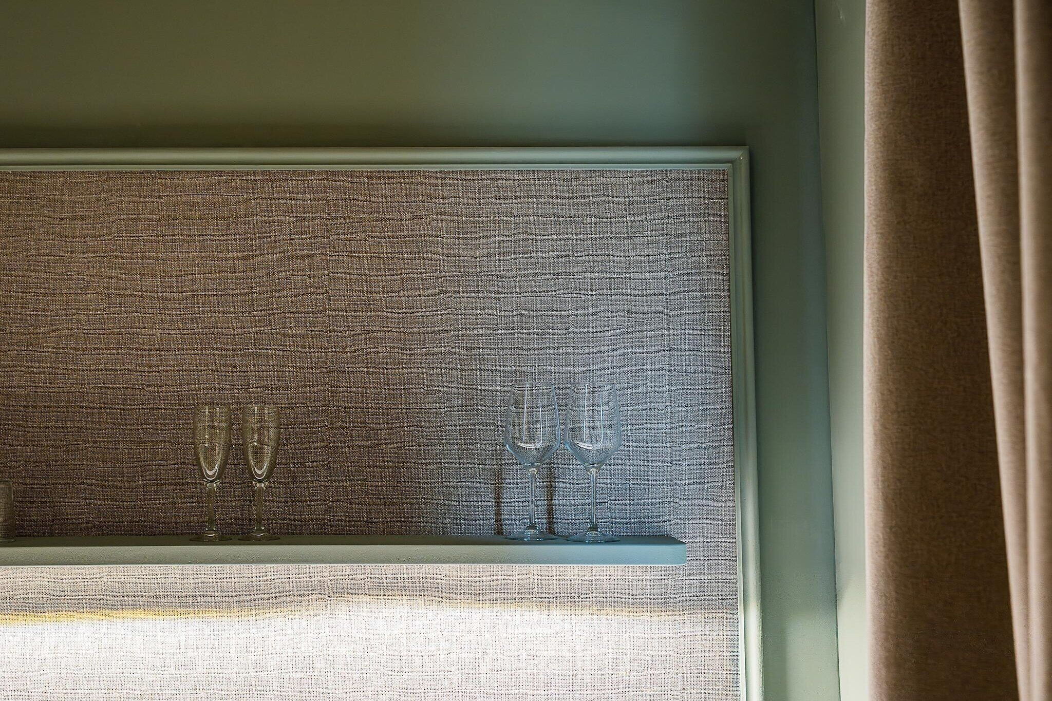 A window with two champagne flutes on a shelf.