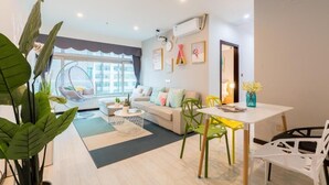 A modern living room with a sofa, chairs, a dining table, and a hanging chair. - Style INS High-Altitude River View Hotel (Chongqing)