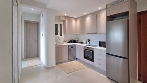 A modern kitchen with a stainless steel refrigerator, built-in oven, and a microwave. - Elegant Apt at Alimos Marina Sea View (Alimos)