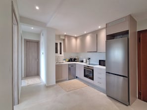 A modern kitchen with a stainless steel refrigerator, built-in oven, and a microwave. - Elegant Apt at Alimos Marina Sea View (Alimos)