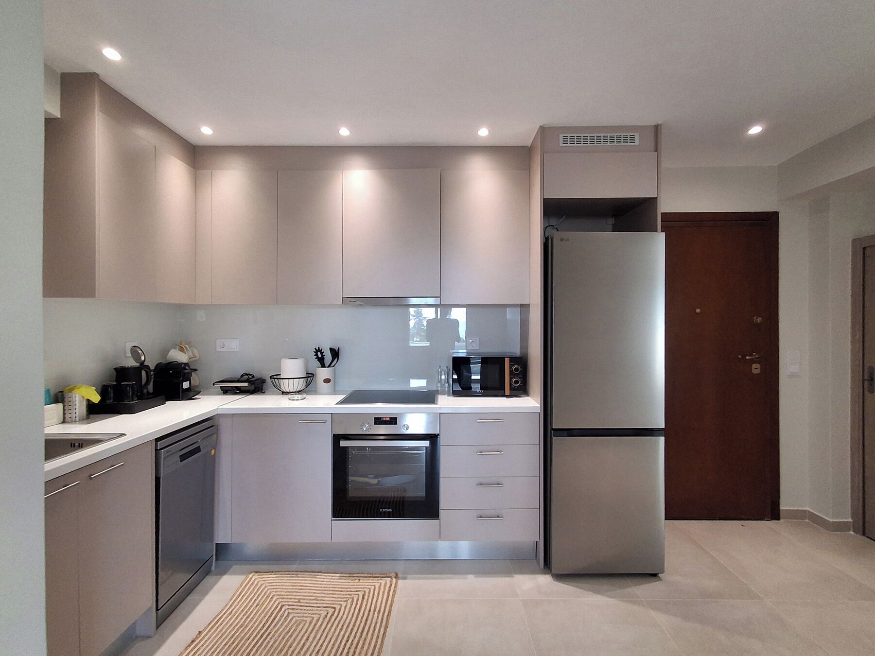 Een moderne keuken met inbouwapparatuur, een vaatwasser en een magnetron.