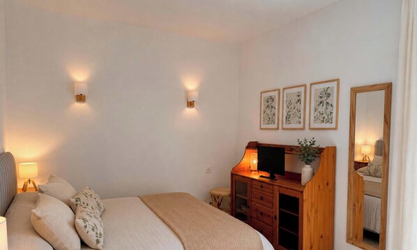A bedroom with a bed, bedside lamps, a desk with a computer, a mirror, and framed botanical prints on the wall. - Villa in Benissa for 6 with air conditioning and private pool - CASA MAGDALENA (Benissa)