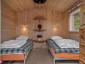 A cabin with two beds, wooden walls, a window, and a shelf with plants. - "Haley" - 380m from the sea by Interhome (Hadsund)