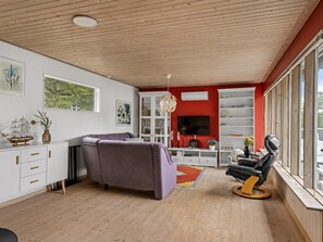 A modern living room with a sofa, a TV, and a dining area. - "Haley" - 380m from the sea by Interhome (Hadsund)