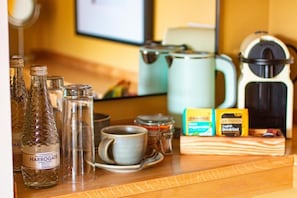 A breakfast bar with Harrogate water, a coffee maker, and breakfast items. - The White Hart Inn  (Ingatestone)