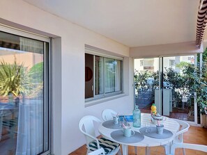 A balcony with a table and chairs, a window, and a view of the outside. - Port Soleil by Interhome (Arcachon)