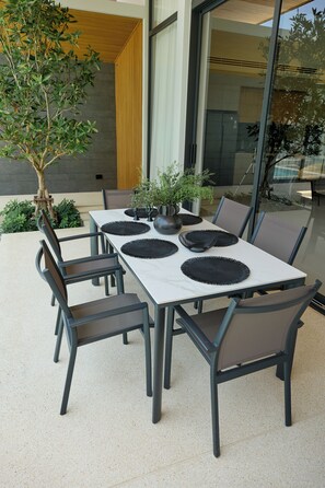 A dining table with chairs, a potted plant, and a vase. - Botanica Four Seasons Villas Tropiclook (Thep Krasatti)