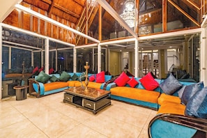 A spacious living area with a large sectional sofa, a coffee table, and a chandelier. - The Pahalgam Dayz (Pahalgam)