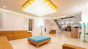 Un salón amplio con un sofá grande, una mesita de centro y una escalera que lleva a otro nivel.