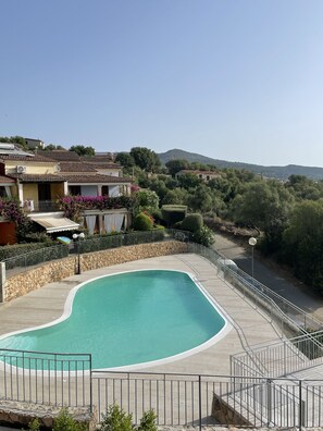 A swimming pool with a curved edge, surrounded by a stone wall and metal railing. - Casa Luna e Sole by Wonderful Italy (Budoni)