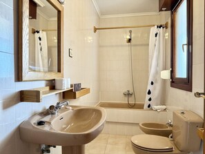 Ein Badezimmer mit Waschbecken, Toilette, Bidet und Badewanne.