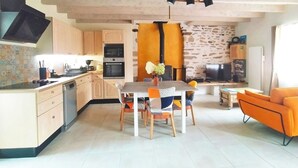Een moderne keuken met een eetgedeelte, een open haard en een televisie.